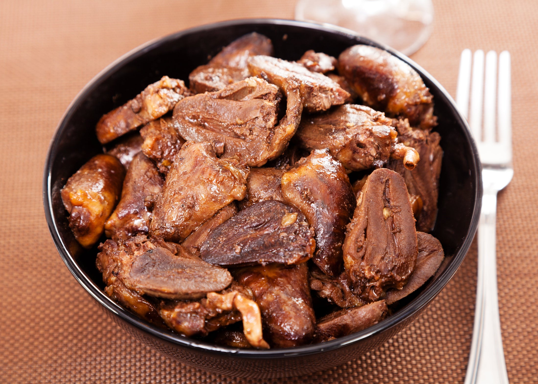 Cooked duck hearts that have been regeneratively raised served in a black bowl